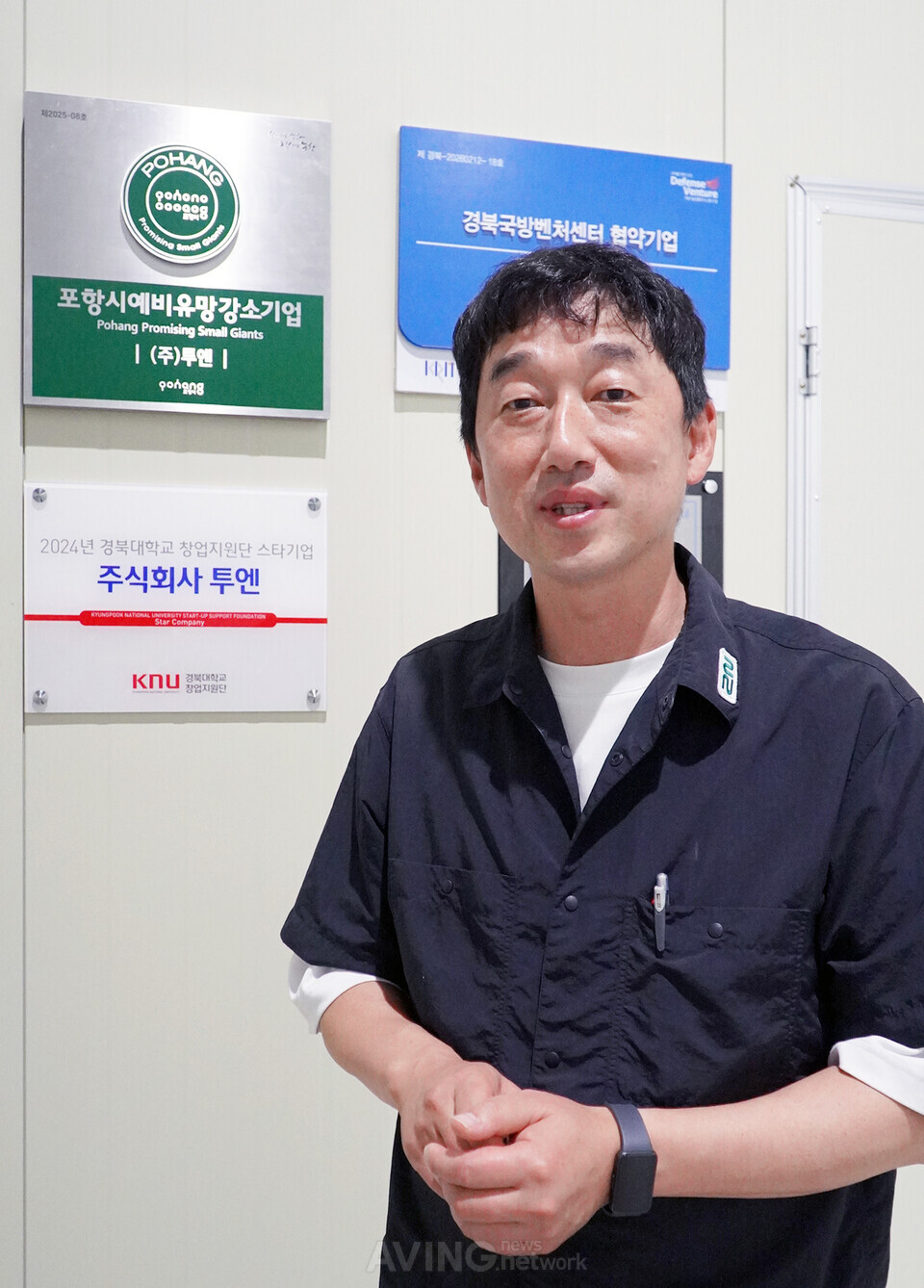 반도체 노광기 공정 엔지니어로 20여 년을 보낸 국내 1세대 엔지니어 출신 김재훈 대표. 뒤로 '포항시 예비 유망강소기업', '경북국방벤처센터 협약기업', '경북대 창업지원단 스타기업' 현판이 나란히 걸려 있다. 창업 5년 차 스타트업이 정유·반도체·방산을 넘나들며 쌓아 올린 공신력을 보여주는 이력의 벽이다. | 촬영 - 에이빙뉴스